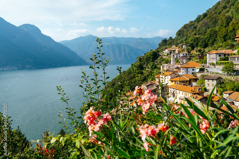 Italy, Lake Lugano. View of the lake, mountains and old houses above the lake.