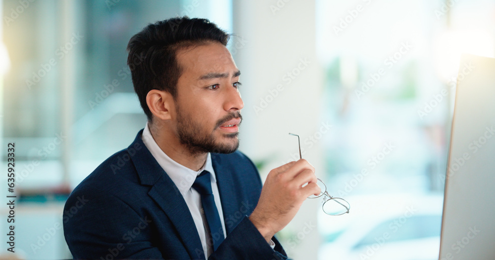 Stressed web developer suffering with mental block while trying to code on a computer in his office.