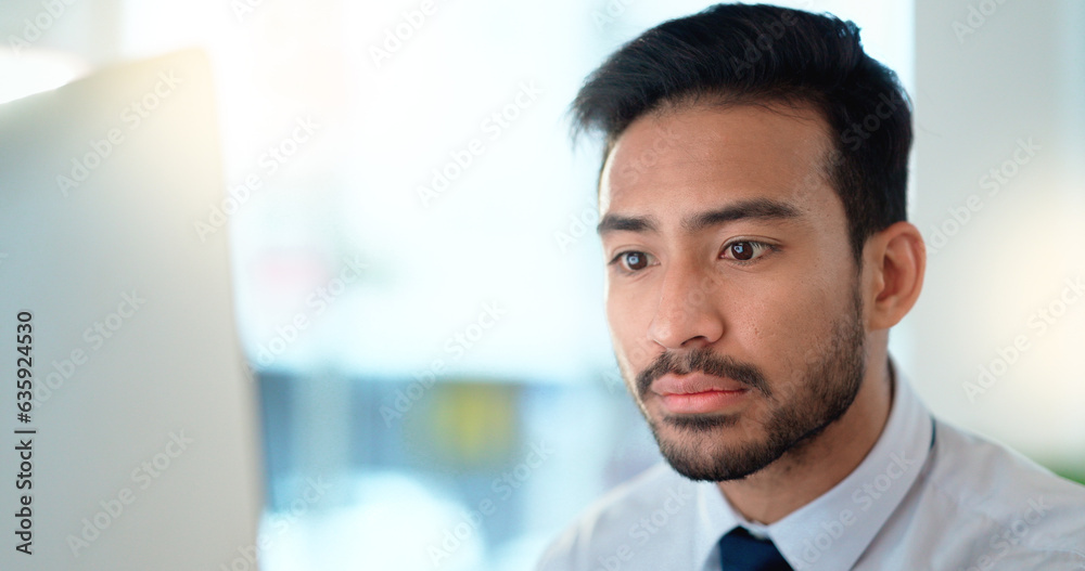 Business man reading his emails and browsing online on a desktop computer while working in an office