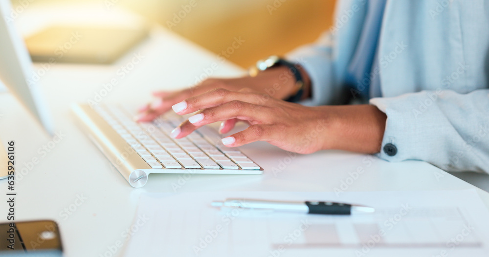 Closeup of a womans hands typing on a keyboard while sitting at a desk and sending an email in an of