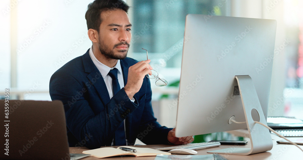 Business man analyzing a project strategy on a computer screen while working in an office. Serious a