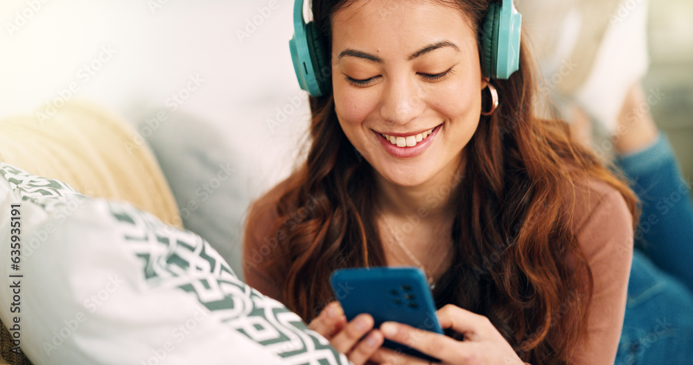 Girl, phone and music on sofa to relax with headphones with smile, typing and happy on social media.