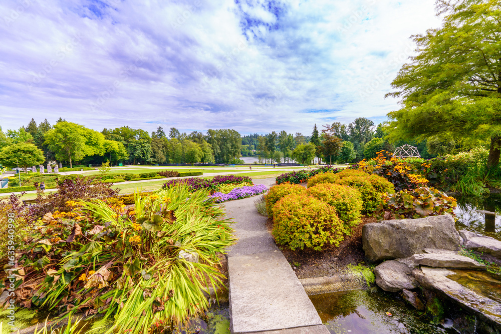 Gardens at Deer Lake Park, Burnaby, BC on a cloudy summer day, with lake in background.