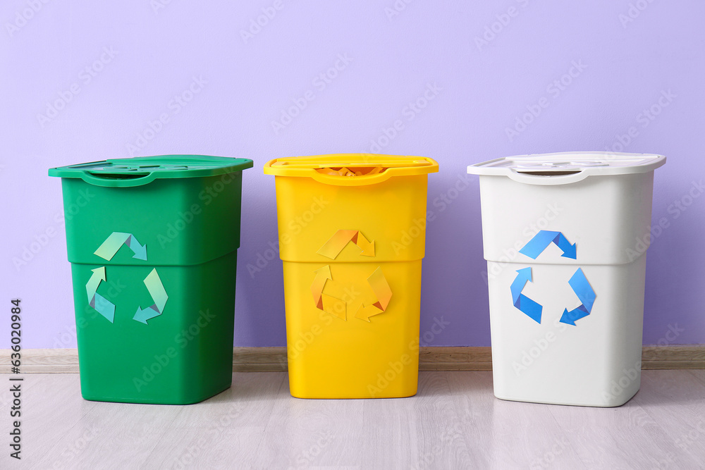 Containers for garbage near lilac wall. Recycling concept