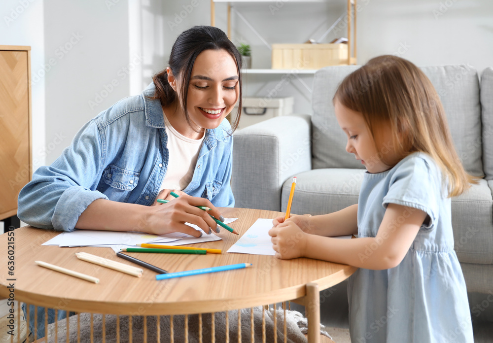 Young woman with her little daughter drawing at home