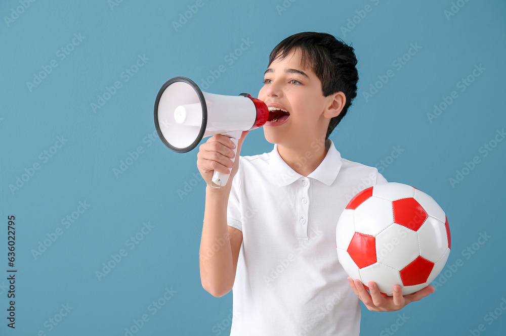 Little boy with soccer ball and megaphone on blue background