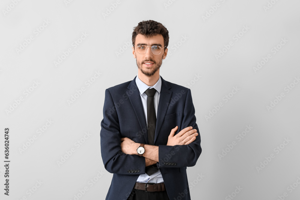 Young businessman in suit on light background