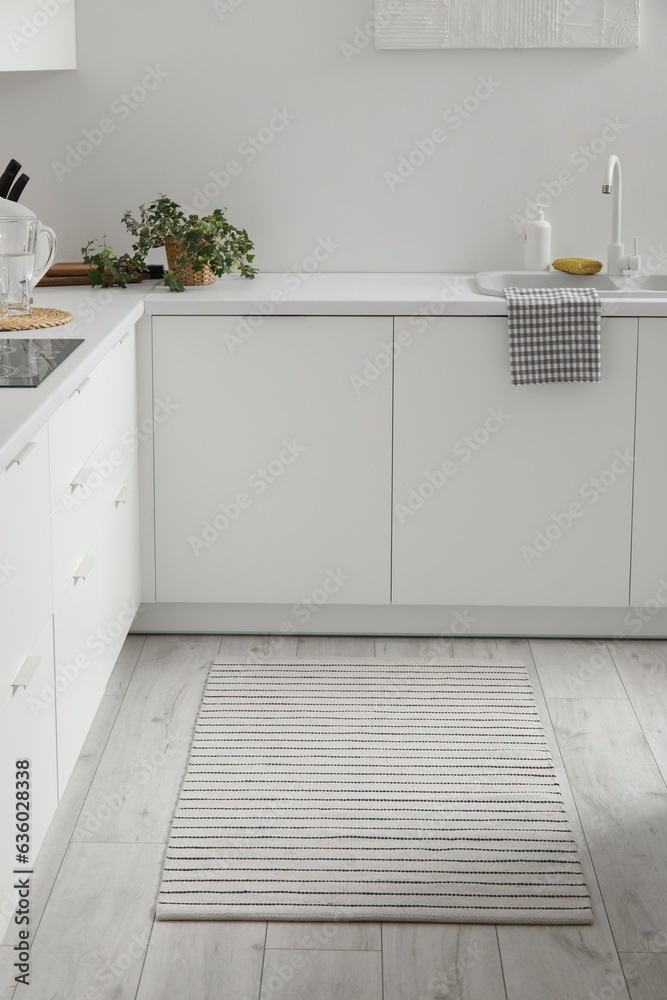 Stylish striped rug in interior of modern kitchen