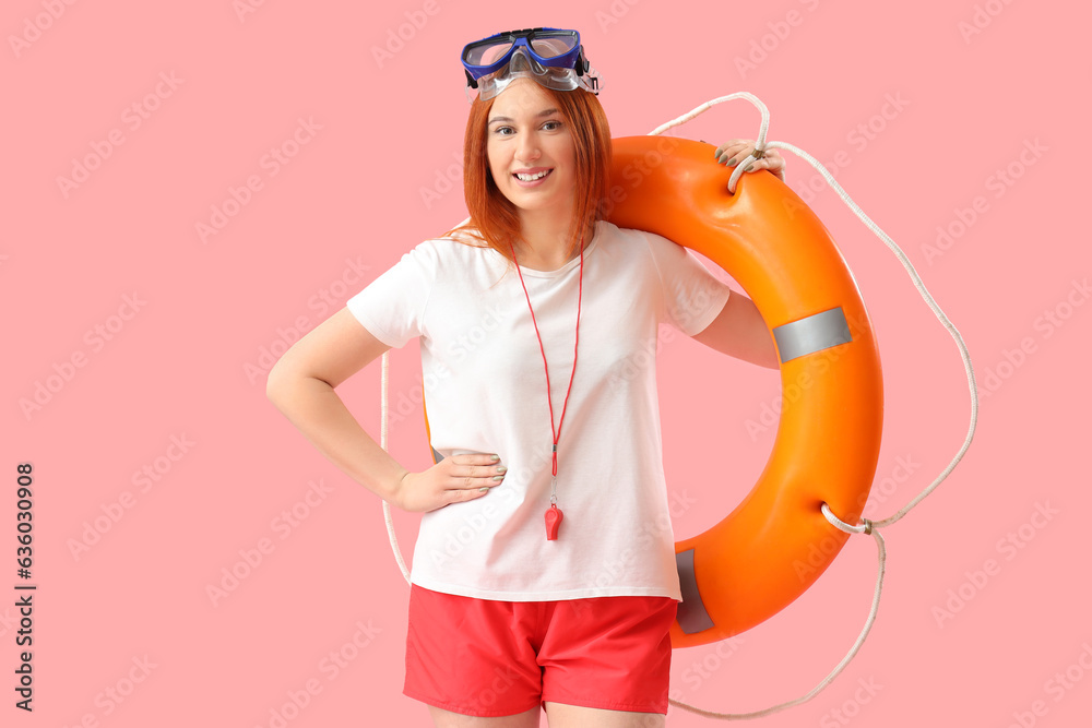 Female lifeguard with snorkeling mask and ring buoy on pink background