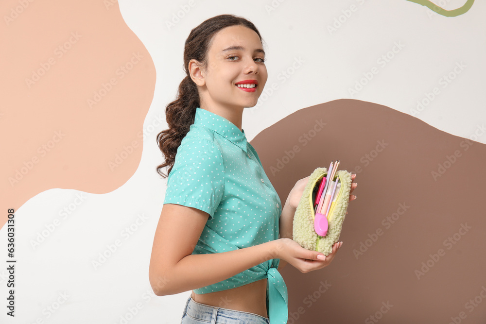 Female student with pencil case on color background