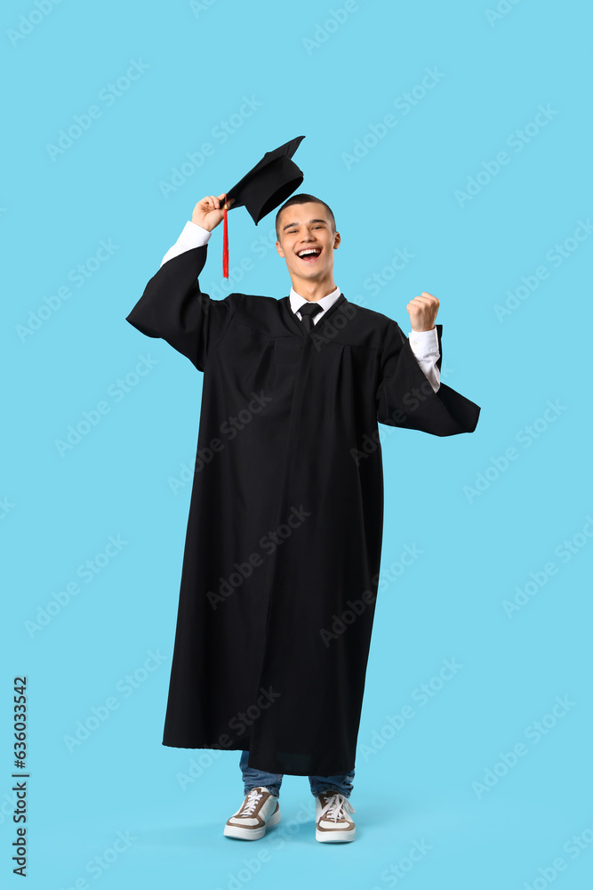 Happy male graduate student on blue background