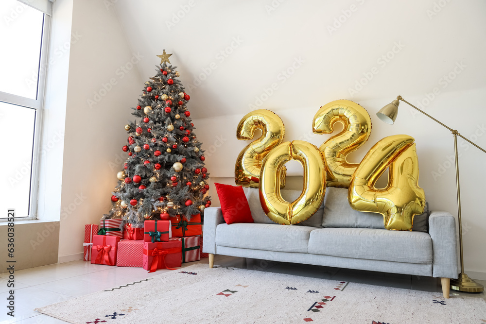 Balloons in shape of figure 2024 on grey sofa in living room with Christmas decor