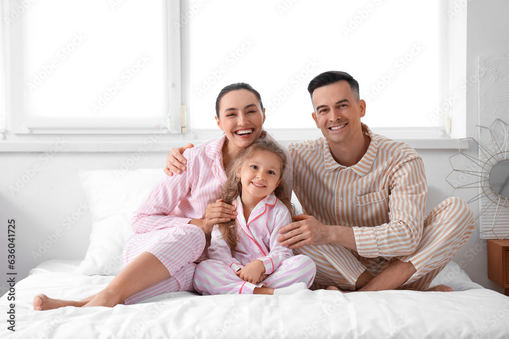 Little girl with her parents in bedroom