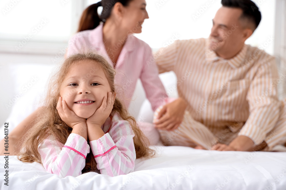 Little girl with her parents in bedroom, closeup