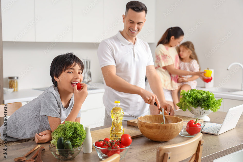 Little boy with his father cooking in kitchen