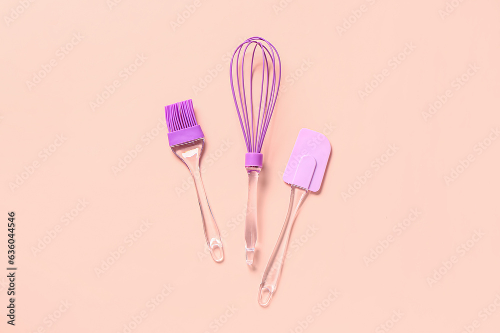 Pastry brush, whisk and spatula on pink background