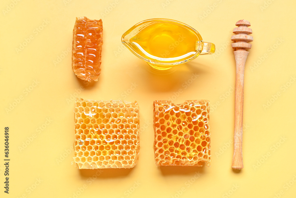 Gravy boat with sweet honey and combs on yellow background