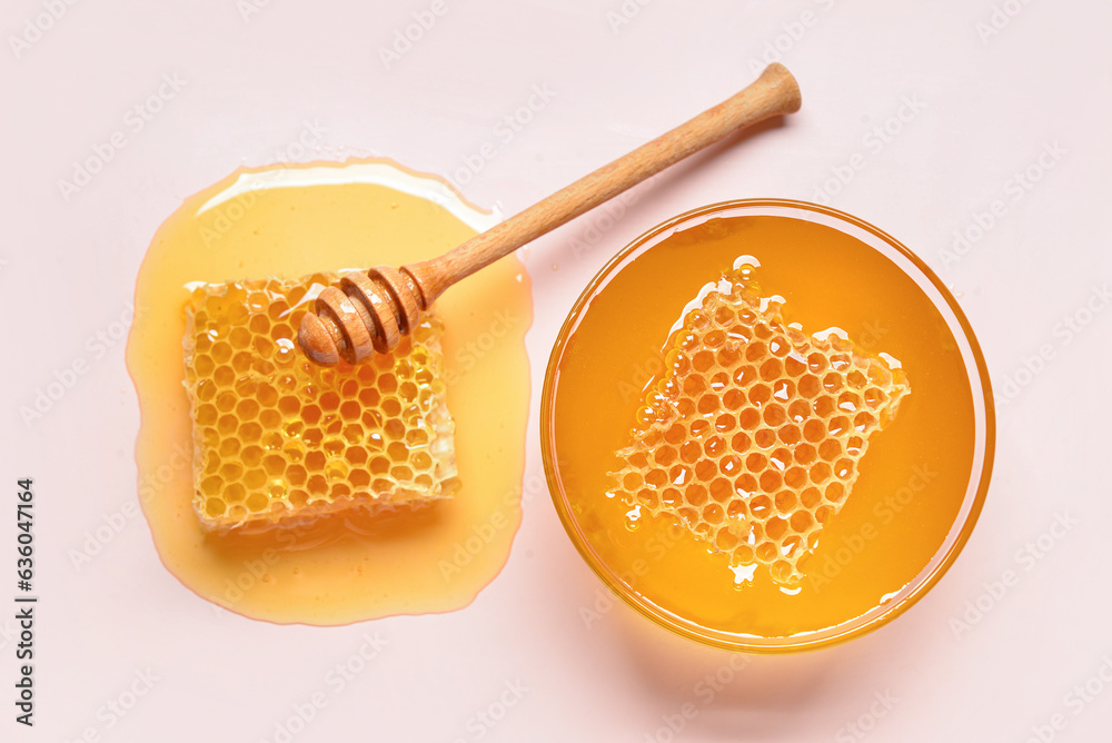 Glass bowl with sweet honey and combs on pink background