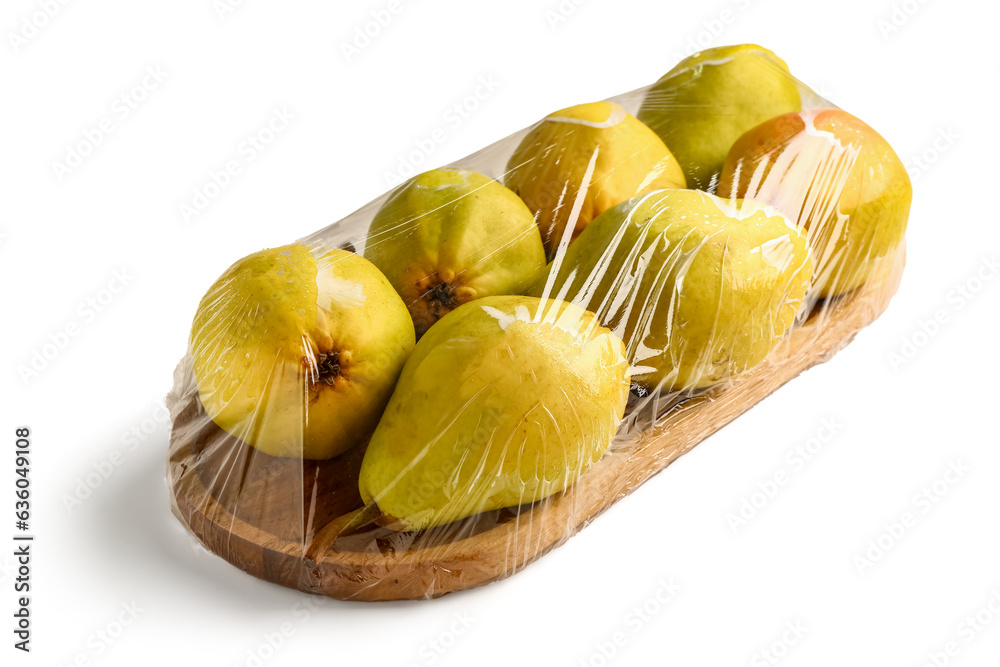 Wooden board of fresh pears covered with plastic food wrap on white background