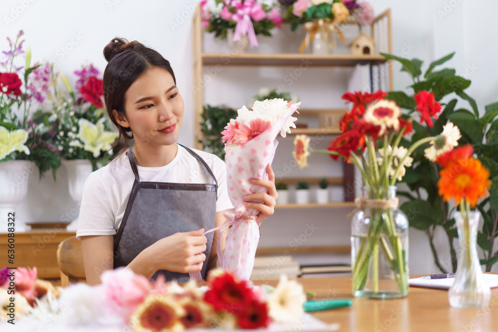 Florist concept, Female florist smile and holding colorful flower bouquet with paper and ribbon bow