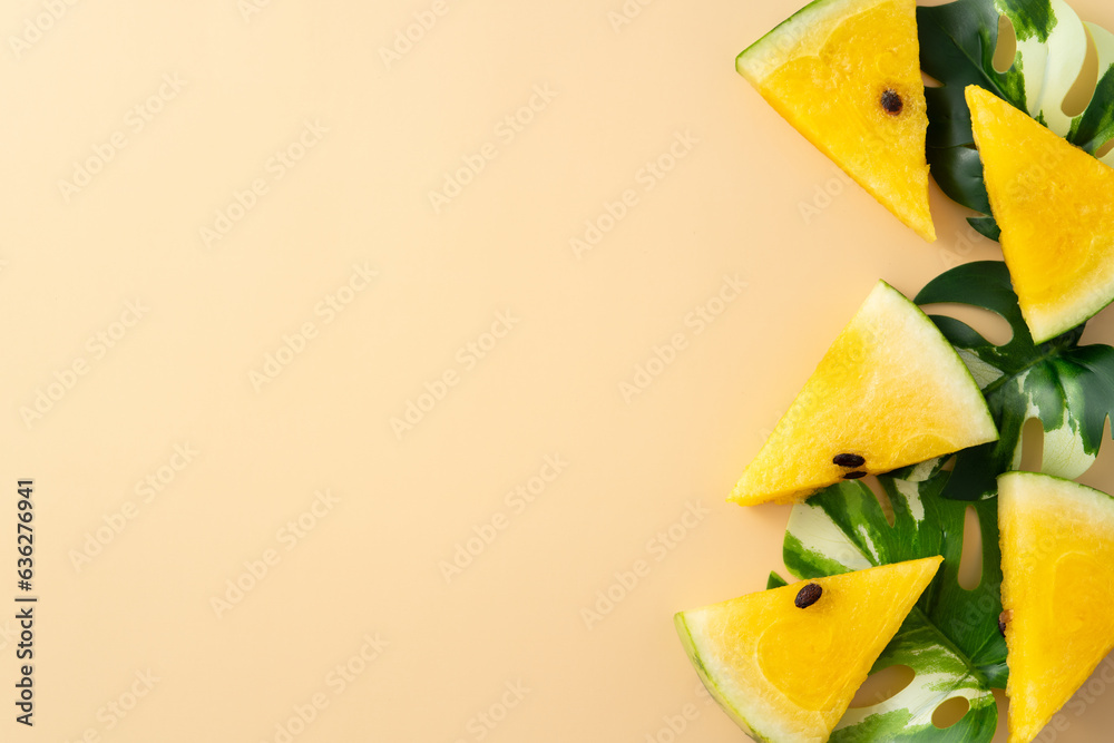 Sliced yellow watermelon with leaves flat lay on pastel yellow table background.