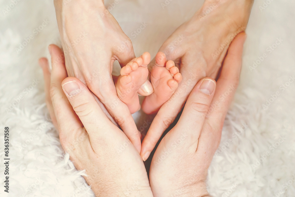 Baby feet in parents hands, making heart shape, love emotions, positive