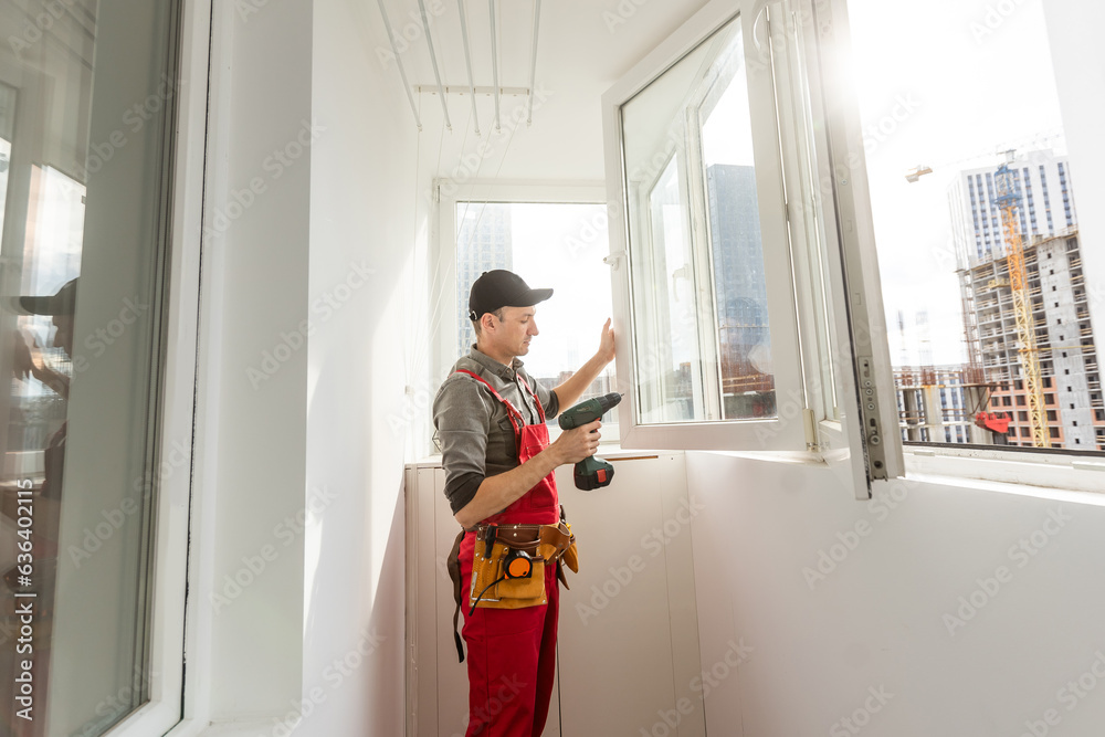 The foreman installs a window frame in the room