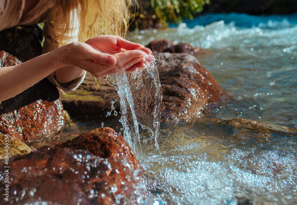 Young woman drinking water from a mountain spring