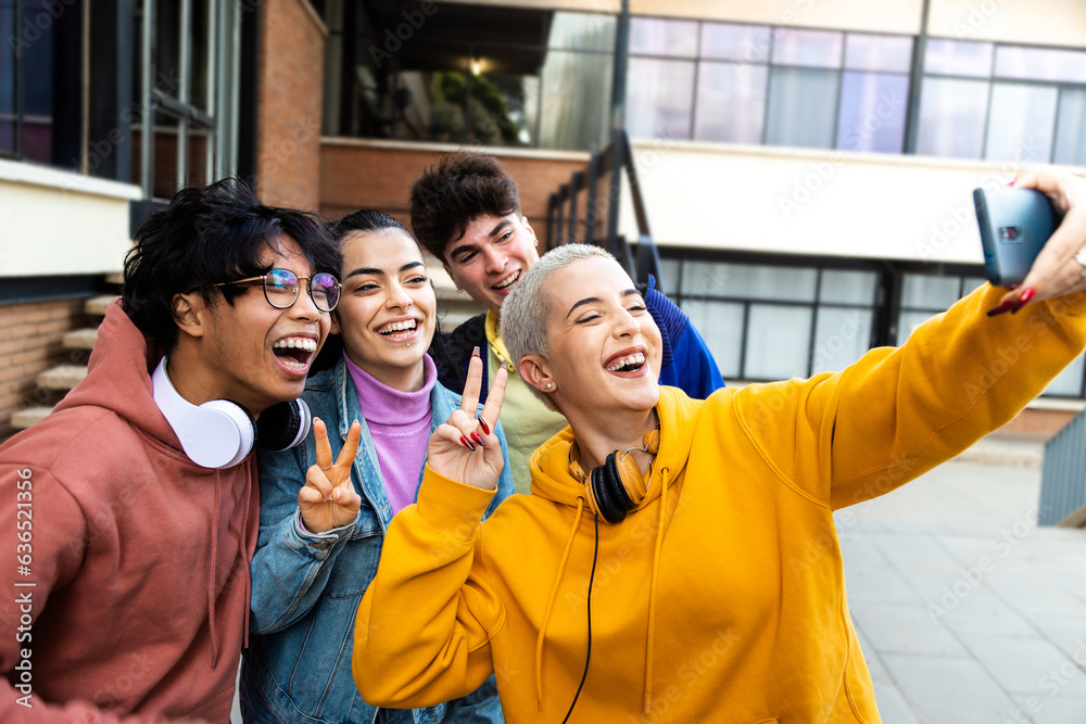 Happy multiracial college student friends take selfie with mobile phone laughing and having fun outs