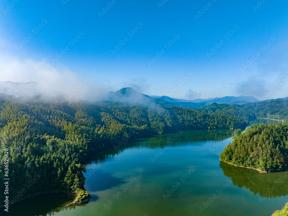 Aerial photography of a large reservoir with blue sky and white clouds and mountains