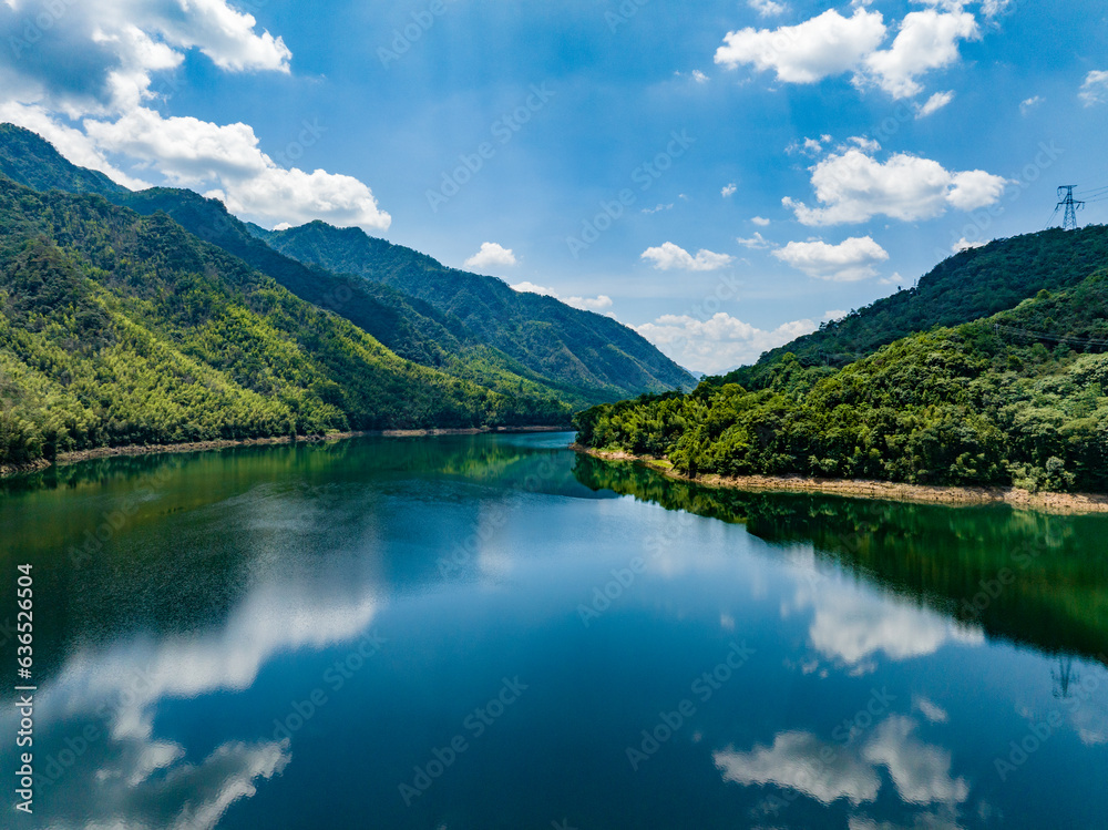 Aerial photography of a large reservoir with blue sky and white clouds and mountains