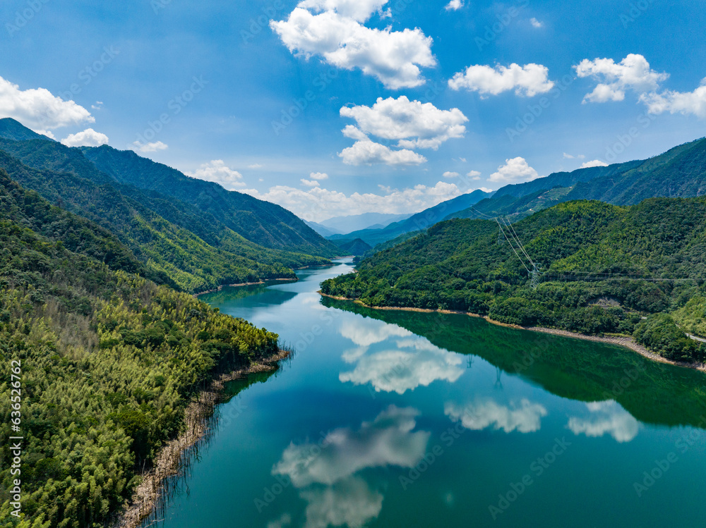 Aerial photography of a large reservoir with blue sky and white clouds and mountains