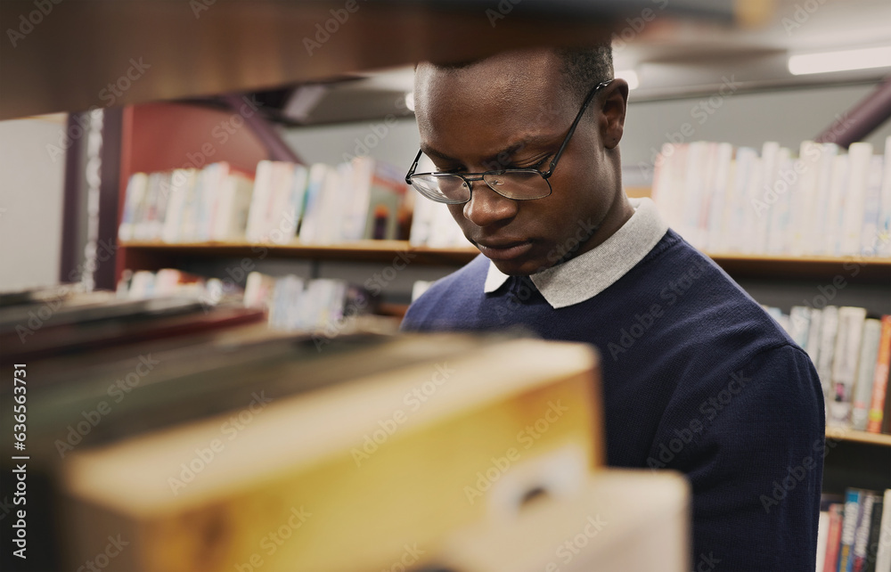 University, student and black man in a library reading and learning on campus for knowledge and educ