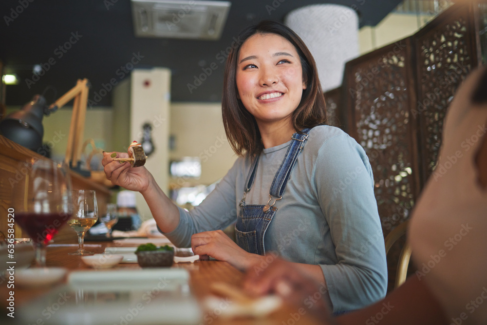 Asian, sushi and woman at a restaurant eating for dinner or lunch meal using chopsticks and feeling 