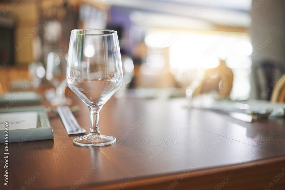 Bokeh, lunch and glass on a table at a restaurant for water, alcohol or wine. Dinner, crystal and ta