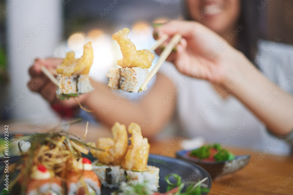 Chopsticks, girl friends hands and shrimp sushi at a table with Japanese cuisine food at restaurant.