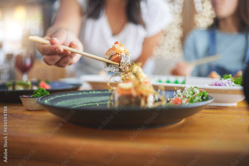 Sushi, hand and eating food with chopsticks at a restaurant for nutrition and health. Closeup of a h