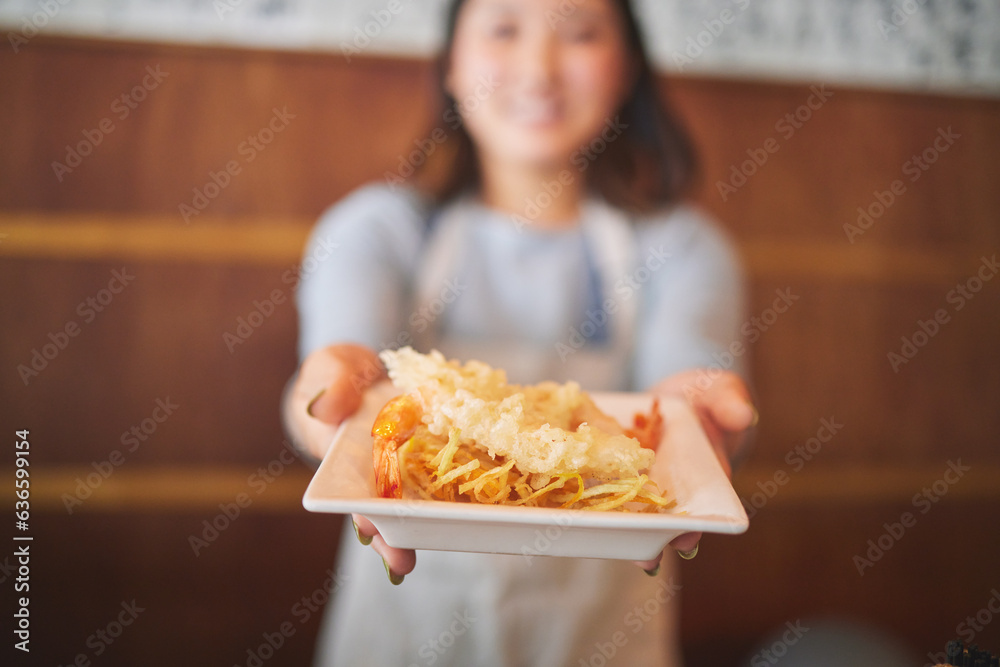 Hands, waitress and woman with seafood on plate, shrimp and tempura for eating at restaurant, cafe o