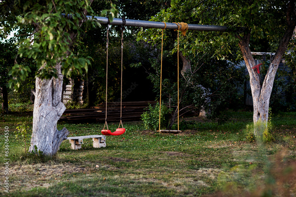 two swings in the garden, filmed on a summer evening