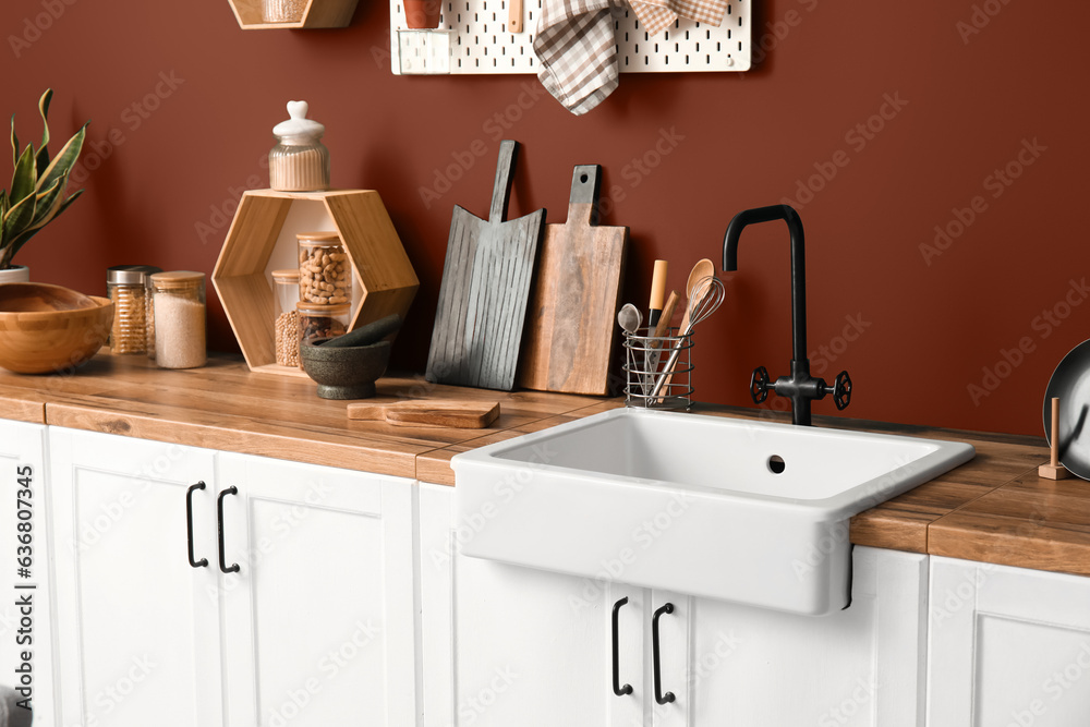 Wooden counters with sink and utensils in modern kitchen