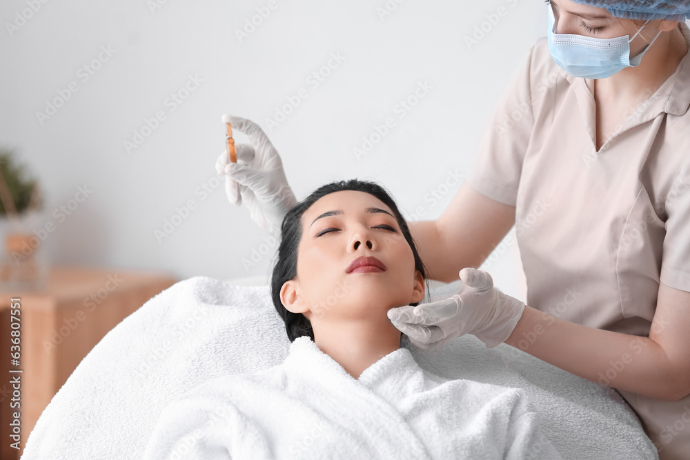 Young Asian woman undergoing treatment in beauty salon. Skin care concept