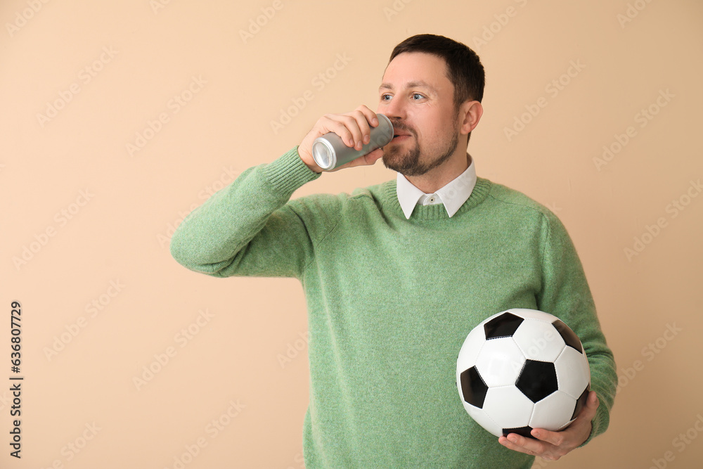 Man with soccer ball and drink on beige background