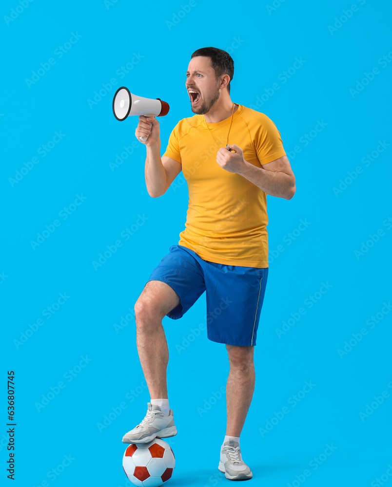 Male coach with soccer ball and megaphone on blue background