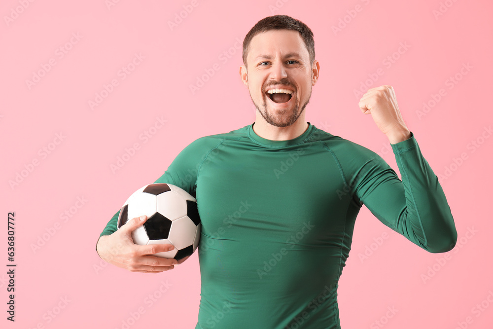 Happy man with soccer ball on pink background