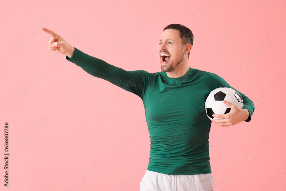 Screaming man with soccer ball on pink background