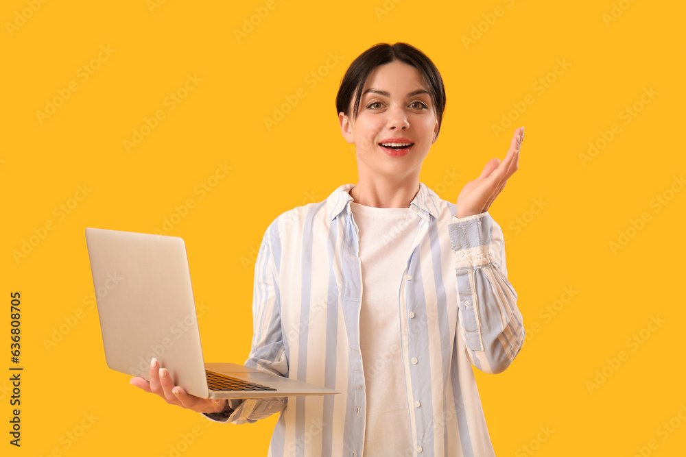 Female programmer with laptop on yellow background