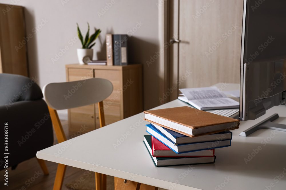 Stack of books on table in living room, closeup