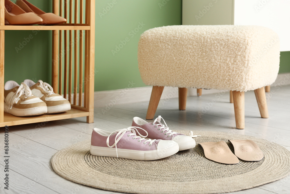 Stylish shoes and orthopedic insoles on floor in room