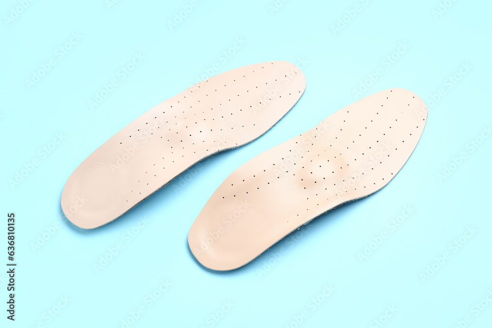 Leather orthopedic insoles on color background