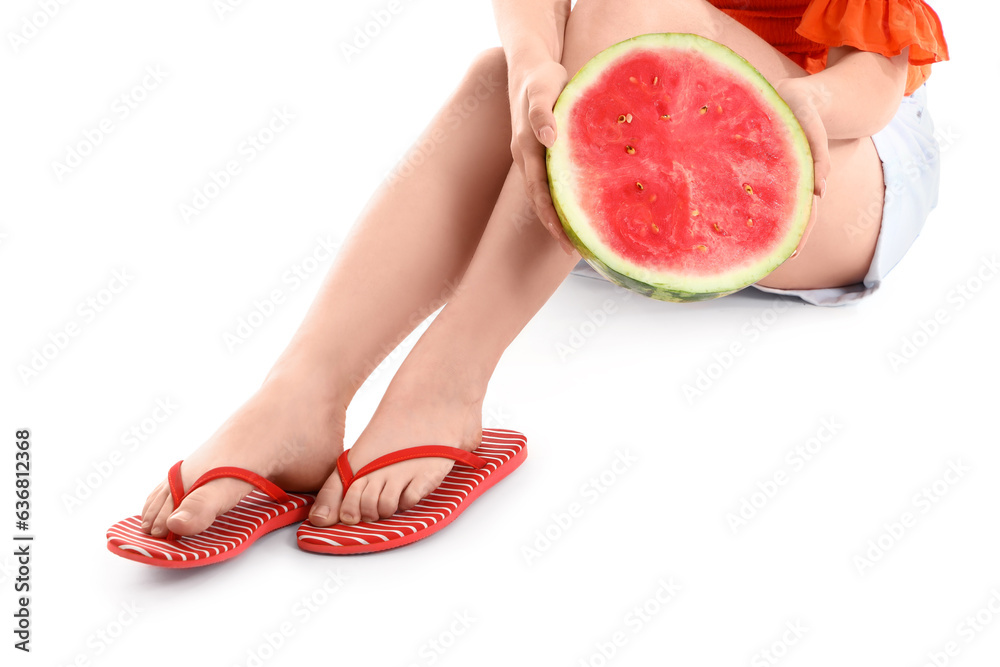 Beautiful young woman in stylish flip flops with watermelon sitting on white background